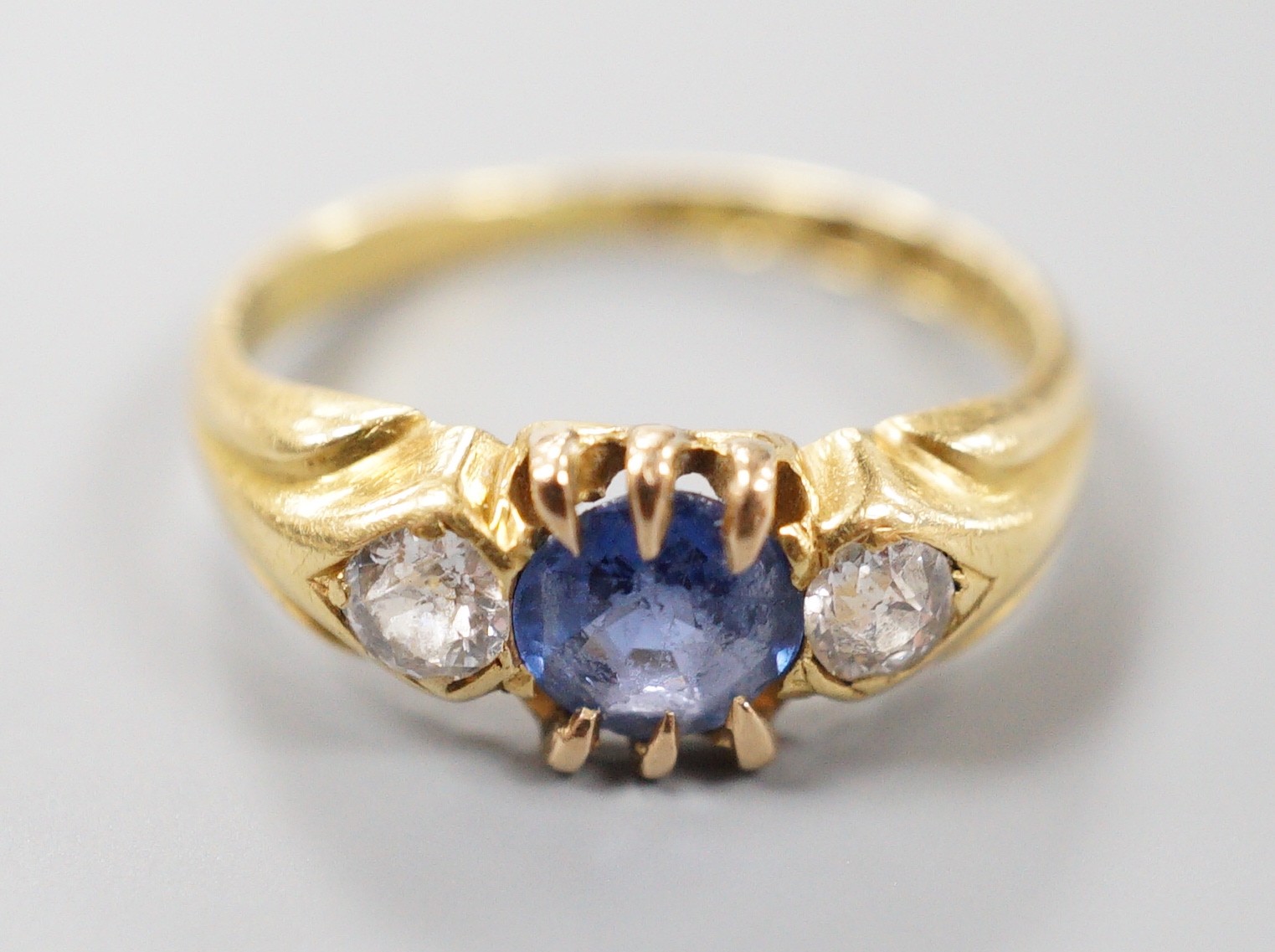 A late Victorian 18ct gold, sapphire and diamond set three stone ring, size I, gross weight 3 grams.